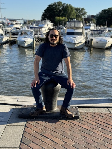 Carlos The Medium sits on a bollard at the Old Town Alexandria waterfront